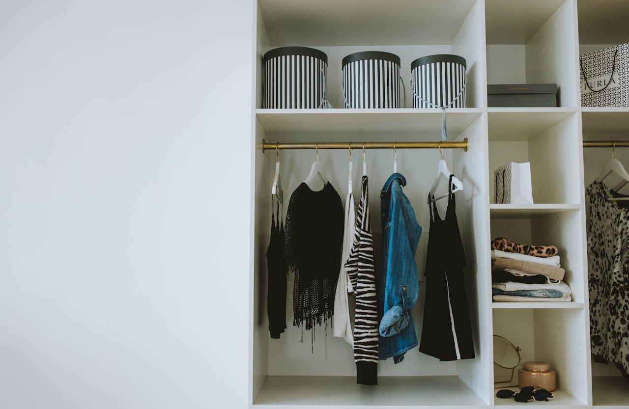 Organized wardrobe with trendy clothes, hangers, and storage boxes.